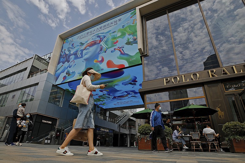 Shoppers walk Wednesday through a popular shopping mall in Beijing. The rebounding Chinese and U.S. economies is bolstering global economic prospects for this year.
(AP/Andy Wong)