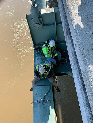 Workers from the Arkansas and Tennessee transportation departments inspect the cracked beam Wednesday on the Interstate 40 Mississippi River bridge between West Memphis and Memphis. The break is just in front of the worker straddling the beam. (Special to the Arkansas Democrat-Gazette)