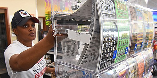 Sekoiyn Phillips, a Corner Store cashier, pulls lottery scratch off tickets for a customer Wednesday, May 12, 2021 at the Corner Store on Stagecoach Road in Little Rock.. (Arkansas Democrat-Gazette/Staci Vandagriff)