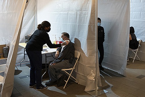 Covid-19 shots are given Wednesday at a temporary vaccination clinic at the Coney Island-Stillwell Avenue subway station in New York.
(The New York Times/James Estrin)