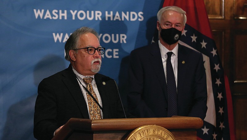 Arkansas Health Secretary Dr. Jose Romero addresses a press conference at the state Capitol in Little Rock as Gov. Asa Hutchinson watches in this Friday, Feb. 26, 2021, file photo. Romero urged Arkansans to get vaccinated, and he also recommended wearing masks and practicing social distancing, even though the mandates on those two practices were becoming guidelines at the time. (Arkansas Democrat-Gazette/Thomas Metthe)