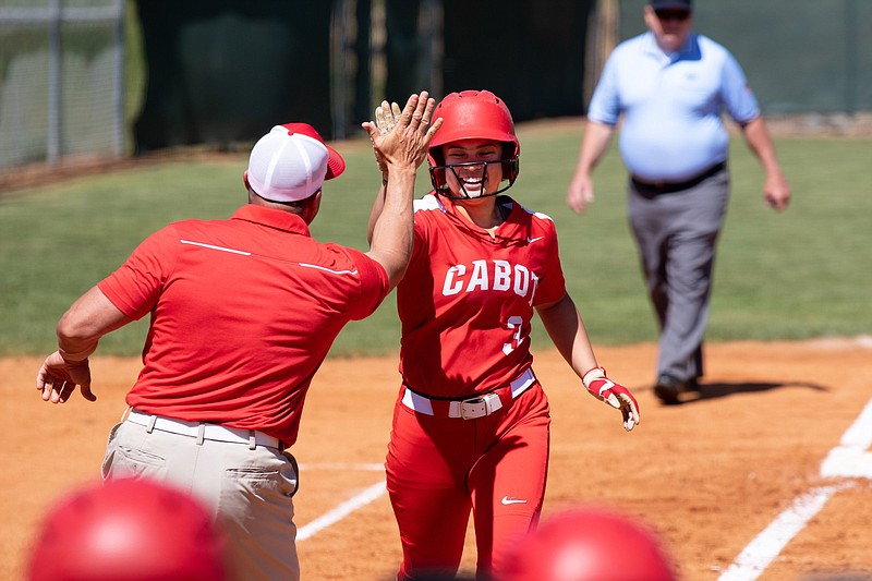 Cabot’s Grace Bear celebrates with Coach Chris Cope after hitting a home run Friday against Fort Smith Southside in the Class 6A state softball tournament in Cabot. The Lady Panthers won 11-9 to advance to today’s semifinals, where they will face Conway at noon.
(Arkansas Democrat-Gazette/Justin Cunningham)