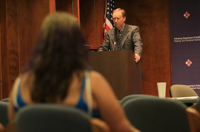 Robert Brech, then the deputy general counsel for the Arkansas Department of Health, opens the floor for comment during a hearing in Little Rock on proposed synthetic marijuana rules in this August 2010 file photo. Smoke shop owner Denise Shelton is shown in the foreground. (Arkansas Democrat-Gazette file photo)