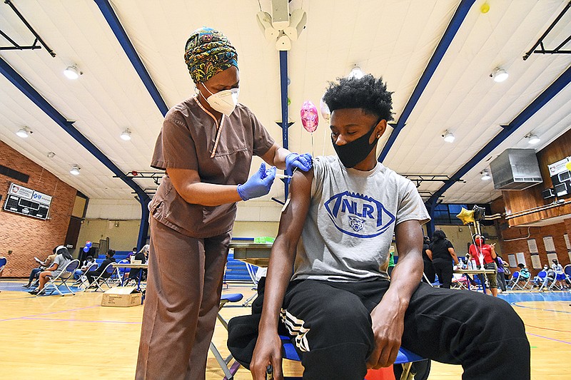 Ed’Regina Barnes, a licensed practical nurse, gives Jakobe White, 16, his first dose of the Pfzier coronavirus vaccine Saturday, May 15, 2021 during a vaccination clinic at Dunbar Community Center in Little Rock. (Arkansas Democrat-Gazette/Staci Vandagriff)