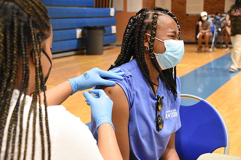 Alyncia Jones, 13, gets her first dose of the Pfzier coronavirus vaccine Saturday, May 15, 2021 from Haley Wilson, a registered nurse, during a vaccination clinic at Dunbar Community Center in Little Rock. (Arkansas Democrat-Gazette/Staci Vandagriff)