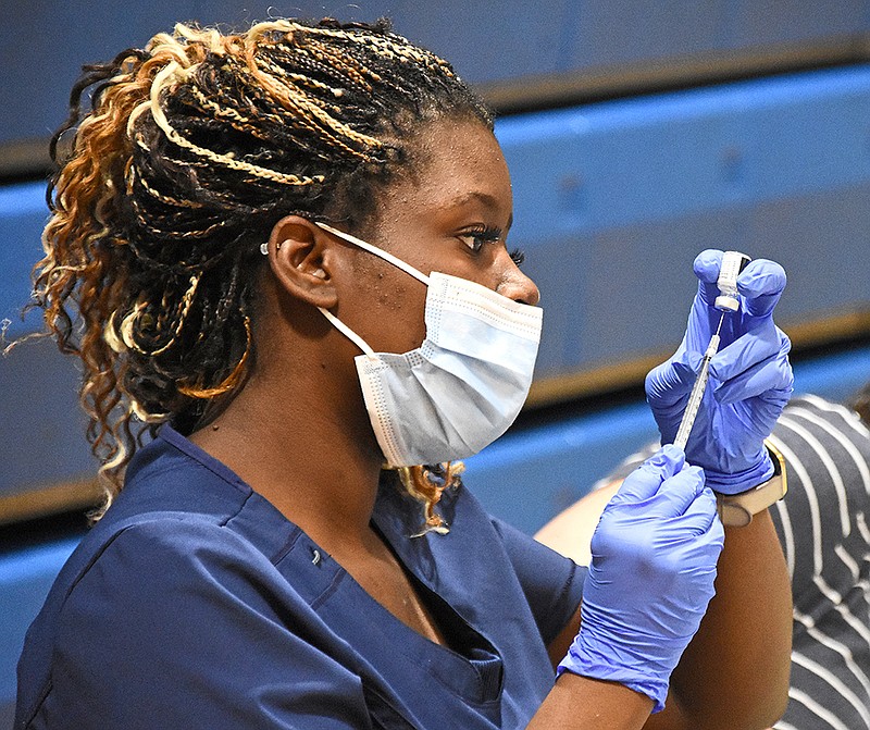 Donyale Pace, a licensed practical nurse, prepares doses of the coronavirus vaccine Saturday, May 15, 2021, during a vaccination clinic at Dunbar Community Center in Little Rock. (Arkansas Democrat-Gazette/Staci Vandagriff)