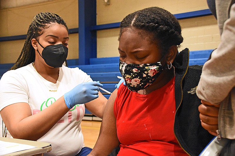 Madison Pride, 12, gets her first dose of the Pfzier coronavirus vaccine Saturday, May 15, 2021 from Haley Wilson, a registered nurse, during a vaccination clinic at Dunbar Community Center in Little Rock. (Arkansas Democrat-Gazette/Staci Vandagriff)