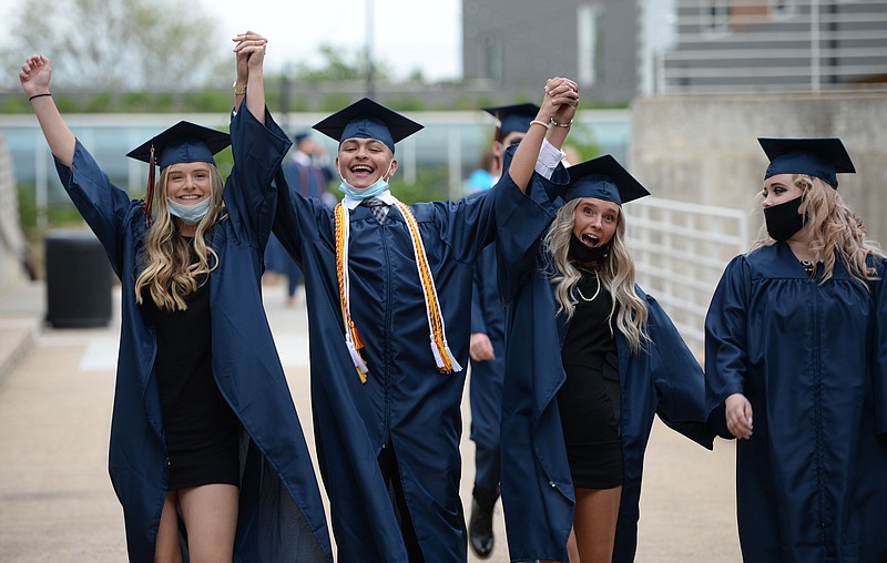 Berkley Cole (from left), Garrison Carroll, Austyn Cravey and Destiany Jones, all graduating seniors at Rogers Heritage High School, walk in together Friday, May 14, 2021, before the start of commencement exercises in Bud Walton Arena in Fayetteville. The school graduated 485 seniors over the course of two graduation ceremonies Friday. Visit nwaonline.com/210515Daily/ for today's photo gallery.
(NWA Democrat-Gazette/Andy Shupe)