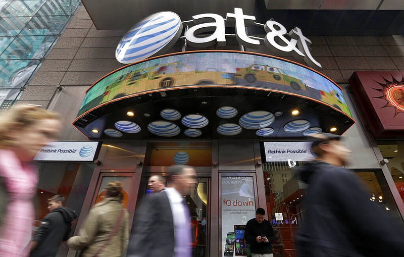 FILE - In this Oct. 21, 2014 file photo, people pass an AT&T store in New York's Times Square. AT&T will combine its media operations that include CNN HBO, TNT and TBS in a $43 billion deal with Discovery, the owner of lifestyle networks including the Food Network and HGTV. (AP/Richard Drew, File)