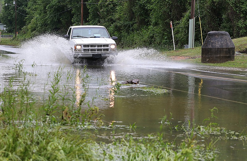 A truck rolls through water running across Brookwood Road in Alexander early Wednesday. Many creeks and low-lying areas in Central Arkansas were flooded by heavy rainfall.
(Arkansas Democrat-Gazette/Thomas Metthe)