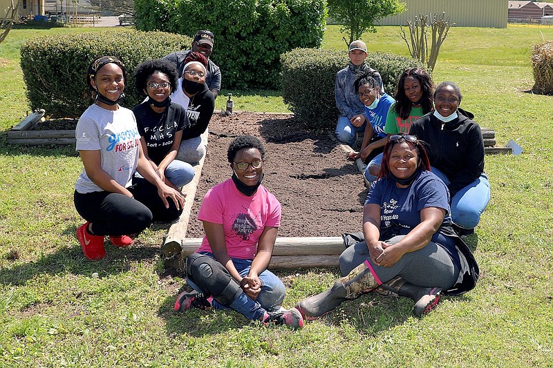 Volunteers replace soil in the flower beds. Pictured are (left, from front to back) Morgan White, Brittney Eskridge, Tamil Clark, Lakesha Cleveland and Trenton Willis and (right, from front to back) Tomekia White and interim director for the 1890 Scholarships Program, along with Tyonna Hayes, Jurnea Stanley, Madison Purifoy and Justin Harrison. 
(Special to The Commercial)