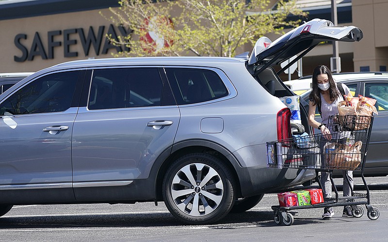 A shopper loads her groceries outside a Safeway in Aurora, Colo. Some grocery chains, including Safeway, are keeping their mask requirements, while other grocers, discount chains, restaurants, hospitals and employers scramble to decide what to do.
(AP/David Zalubowski)