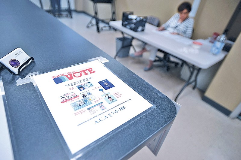 A voter identification reminder is taped to a counter at the Benton County Clerk's office in Bentonville in this May 2014 file photo. (NWA Democrat-Gazette file photo)