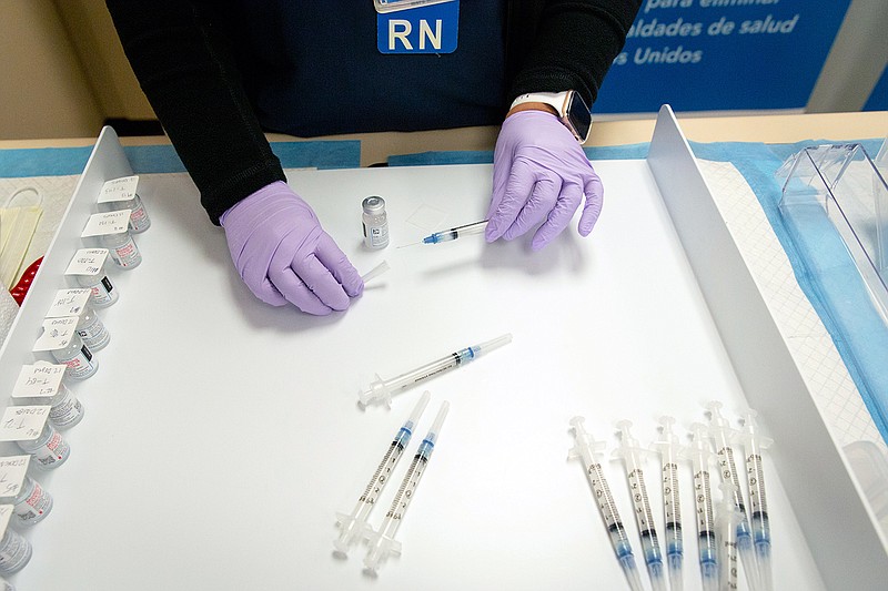 A nurse prepares doses of Moderna vaccine in April at a medical office in Los Angeles. Moderna and Pfizer are testing the timing and efficacy of booster doses, with Moderna developing a low-dose version of its current vaccine and another version customized for the South African strain.
(The New York Times/Allison Zaucha)