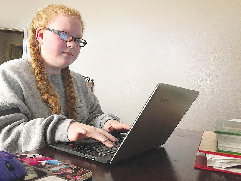 Madalyn Bryson, 14, a ninth grader at Marmaduke High School, composes an email to her physical education teacher from her bedroom in this December 2020 file photo. Madalyn switched to virtual learning after Thanksgiving as virus cases increased at the school. (NWA Democrat-Gazette/Dave Perozek)