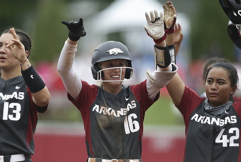 Arkansas’ Keely Huffine (center), Kayla Green (left), Sam Torres and their teammates call the Hogs with fans after their victory over Manhattan on Friday in the NCAA Fayetteville Regional. The Razorbacks take on South Dakota State today. More photos available at arkansasonline.com/522mcua.
(NWA Democrat-Gazette/Charlie Kaijo)