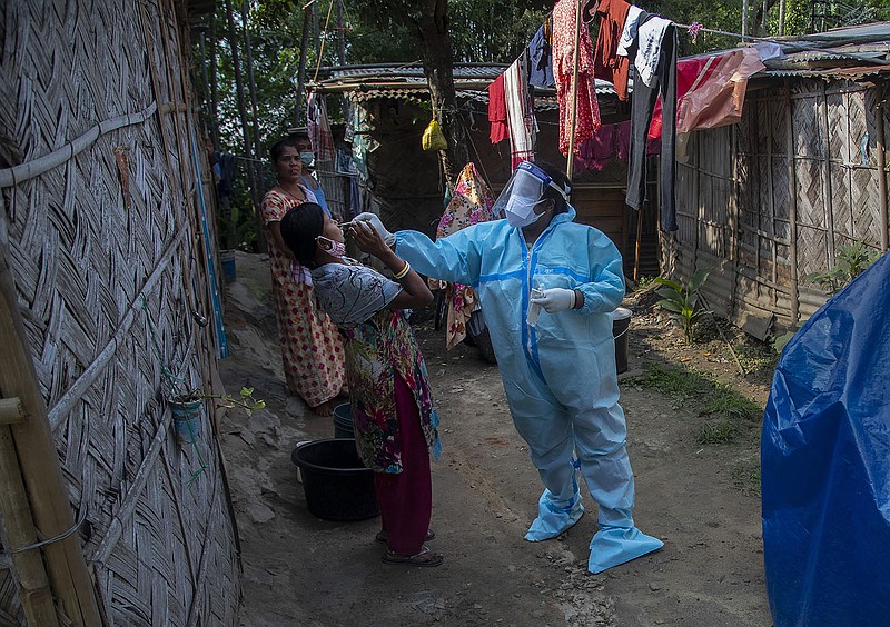 A health worker tests a woman for the coronavirus Friday in Gauhati, India. Confirmed coronavirus cases and deaths have remained below record levels in recent days, but authorities are worried about a fungal infection that attacks those with weak immune systems.
(AP/Anupam Nath)