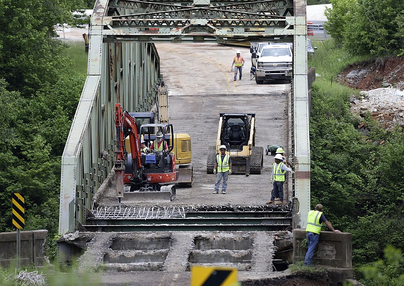 Construction teams work on demolishing the old Pruitt bridge on Arkansas 7 on Thursday. Demolition of the historic span over the Buffalo River began last week after a new bridge opened. Preservationists tried to prevent the demolition, but nobody wanted to assume the cost of maintaining the old bridge.
(NWA Democrat-Gazette/Charlie Kaijo)