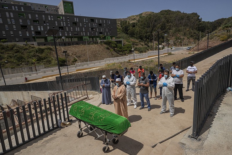 Residents and migrants in Ceuta, Spain, perform a funeral prayer  Saturday for a Moroccan teenager who died Monday trying to swim  across the border from Morocco to Spain’s North Africa enclave.
(AP/Bernat Armangue)