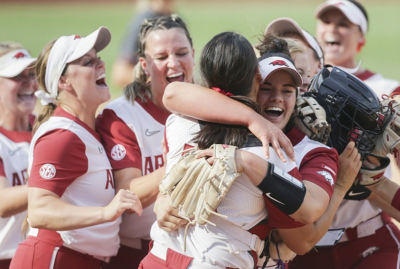 Arkansas pitcher Mary Haff (4) hugs catcher Kayla Green (13) as they celebrate with teammates, Sunday, May 23, 2021 during the NCAA Fayetteville Softball Regional at Bogle Park in Fayetteville. Check out nwaonline.com/210524Daily/ for today's photo gallery. .(NWA Democrat-Gazette/Charlie Kaijo)