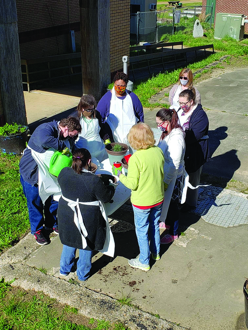 Members of the “Project Search” class from OCH/UAMS along with Amanda Wunnenberg plant flowers around the Little Free Library on the campus of the Fairview Events Center. Photo via The Fairview Events Center Facebook Page.