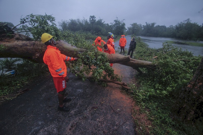 National Disaster Response Force personnel clear trees uprooted Wednesday as Cyclone Yaas intensifi es over the Bay of Bengal in the Balasore district of Odisha, India.
(AP)