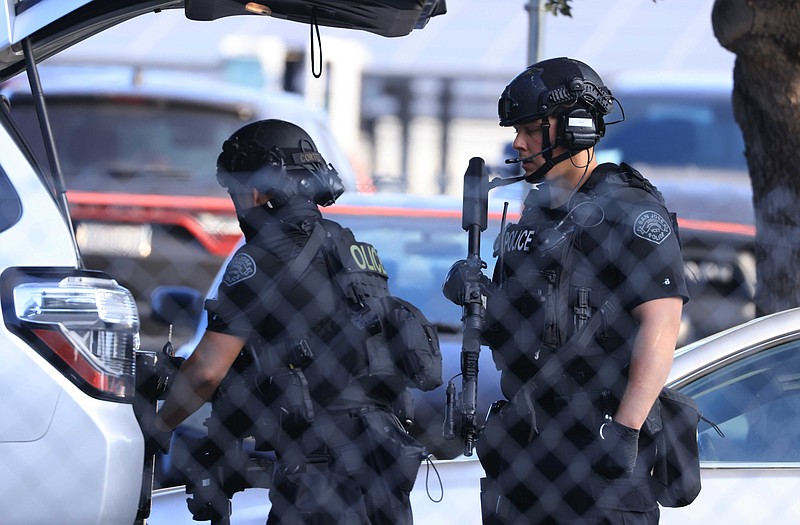 Law enforcement officers get gear from their trunk near the scene of a shooting in San Jose, Calif., on Wednesday, May 26, 2021. Gunfire erupted Wednesday at a railyard in San Jose, and a sheriff’s spokesman said multiple people were killed and wounded and that the suspect was dead. (Randy Vazquez/Bay Area News Group via AP)