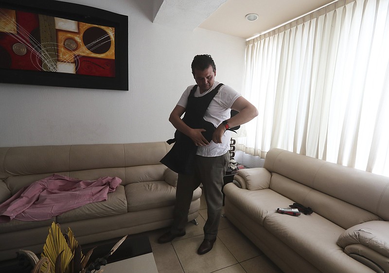 Mayoral candidate Guillermo Valencia straps on a bullet-resistant vest before campaigning last week in Morelia, Mexico. Gunmen wounded two of his staff members in an attack earlier this month.
(AP/Marco Ugarte)