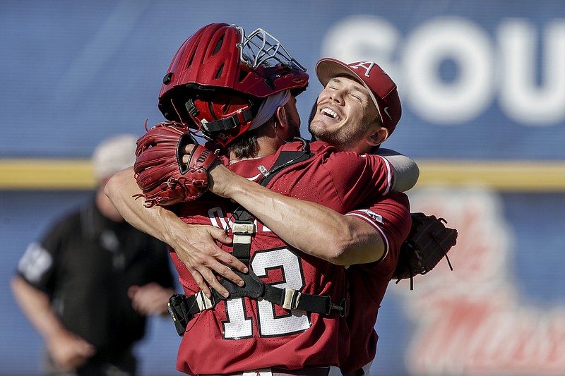 Arkansas catcher Casey Opitz (12) celebrates with pitcher Kevin Kopps after they defeated Tennessee to win the NCAA college baseball championship game during the Southeastern Conference tournament Sunday, May 30, 2021, in Hoover, Ala. (AP Photo/Butch Dill)