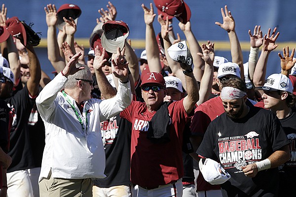 Arkansas coach Dave Van Horn, center, celebrates with the team after defeating Tennessee in an NCAA college baseball championship game during the Southeastern Conference tournament Sunday, May 30, 2021, in Hoover, Ala. (AP Photo/Butch Dill)