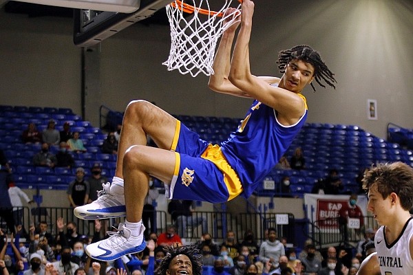 North Little Rock’s Kel’el Ware hangs on the rim after a dunk during the fourth quarter of the Charging Wildcats’ 65-55 victory over Little Rock Central in the Class 6A championship Thursday at Bank OZK Arena in Hot Springs.