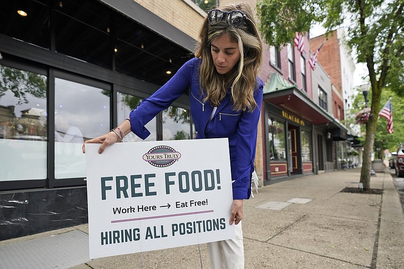 Coleen Piteo, director of marketing at Yours Truly restaurant, puts out a help wanted sign Thursday in Chagrin Falls, Ohio. The number of Americans seeking unemployment benefits fell last week for a fifth straight week.
(AP/Tony Dejak)