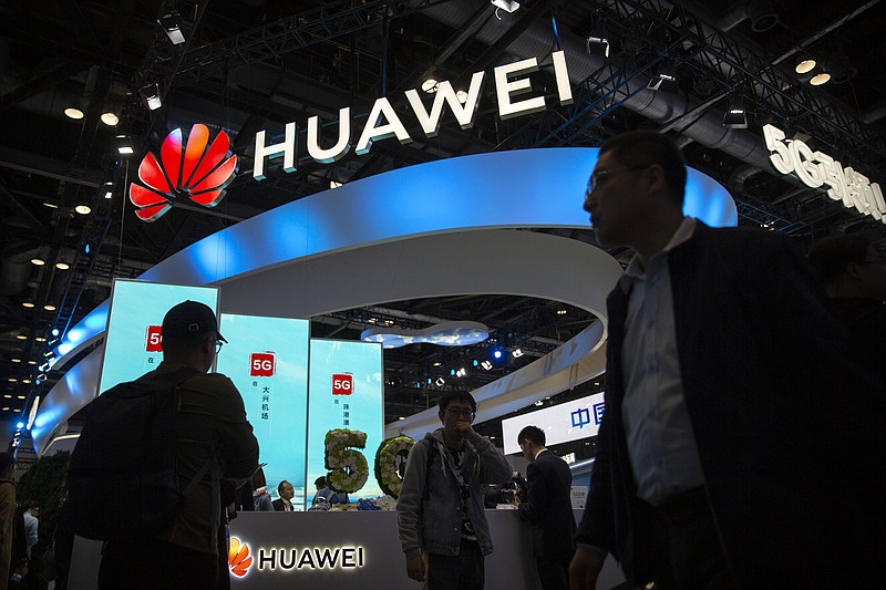 Attendees walk past a display for 5G services from Chinese technology firm Huawei at the PT Expo in Beijing in October of 2019. U.S. President Joe Biden has nearly doubled the list of Chinese companies whose shares are off-limits to U.S. investors.
(AP)