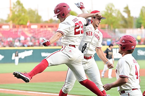 Nebraska's Cam Chick (left) is congratulated after he hit a three-run home run during the fourth inning of an NCAA regional game against Northeastern on Friday, June 4, 2021, in Fayetteville.