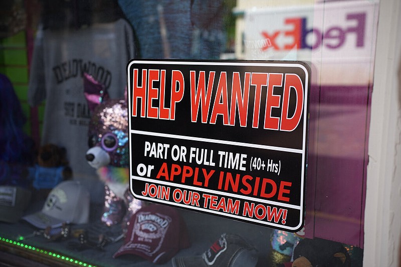 In this May 26, 2021 photo, a sign for workers hangs in the window of a shop along Main Street in Deadwood, S.D. (AP/David Zalubowski)