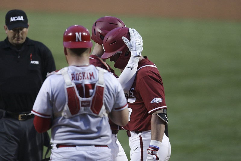 Arkansas infielder Matt Goodheart (10) and Cayden Wallace (7) embrace after a score Saturday, June 5, 2021 during the first inning in the second game of the NCAA Fayetteville Regional at Baum-Walker Stadium in Fayetteville. (NWA Democrat-Gazette/Charlie Kaijo)
