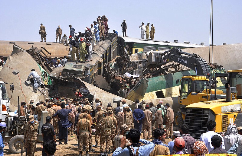 Soldiers and volunteers work at the site of a train collision in the Ghotki district in southern Pakistan, Monday, June 7, 2021. Two express trains collided in southern Pakistan early Monday, killing dozens of passengers, authorities said, as rescuers and villagers worked to pull injured people and more bodies from the wreckage. (AP Photo/Waleed Saddique)