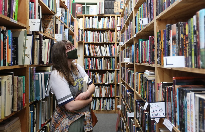FILE -- Jessica Pollard looks at a variety of books Thursday, May 27, 2021, inside the Dickson Street Bookshop in Fayetteville. The store was closed for several months during the pandemic. Government sales tax revenue kept growing. 
(NWA Democrat-Gazette/David Gottschalk)