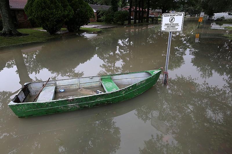 A boat sits tied to a sign Wednesday on a street in Dumas. About 300 businesses in the city have flooded, according to the county judge for Desha County.
(Arkansas Democrat-Gazette/Thomas Metthe)