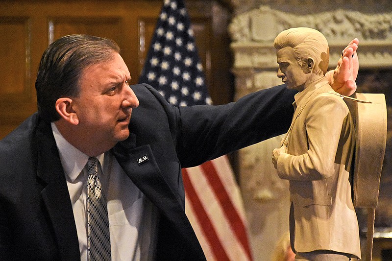 Shane Broadway, chairman of the National Statuary Hall steering committee, blocks the light to get a better look at one of the clay sculptures of musician Johnny Cash during the Capitol Arts and Grounds Commission session Wednesday at the state Capitol. More photos at arkansasonline.com/610sculptures/.
(Arkansas Democrat-Gazette/Staci Vandagriff)