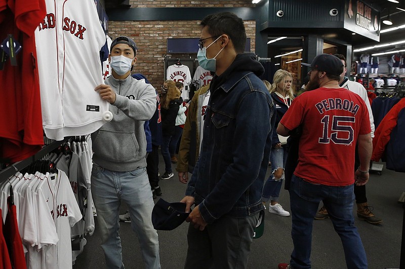 Fans shop at the Boston Red Sox team store before a baseball game in Boston in May as covid-19 restrictions were being lifted in  Massachusetts. The National Retail Federation has revised its sales projections higher for 2021.
(AP)