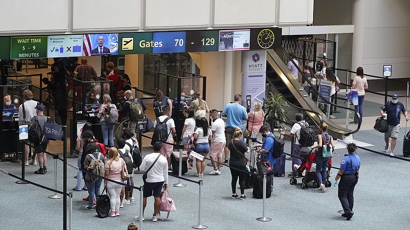 Travelers line up  to go  through a Transportation Security Administration checkpoint at Orlando International Airport on May 28.
(AP/John Raoux)