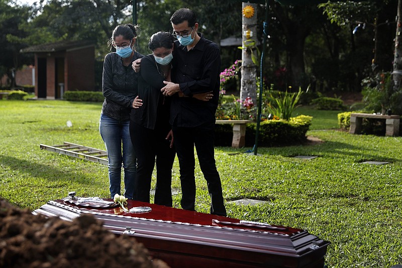 Relatives mourn Martin Cantero, who died of covid-19, Wednesday in Limpio, Paraguay. Paraguay’s Health Ministry said the nation has surpassed 10,000 covid-19 related deaths.
(AP/Jorge Saenz)