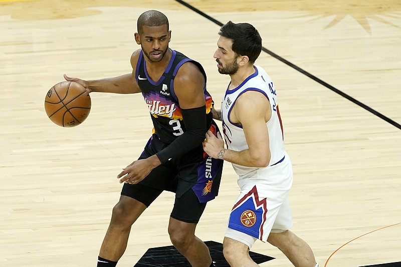 Chris Paul (left) of the Phoenix Suns dribbles against Denver Nuggets guard Facundo Campazzo during the Suns’ victory Wednesday night. Paul had 17 points, 15 assists and no turnovers as Phoenix took a 2-0 series lead.
(AP/Matt York)