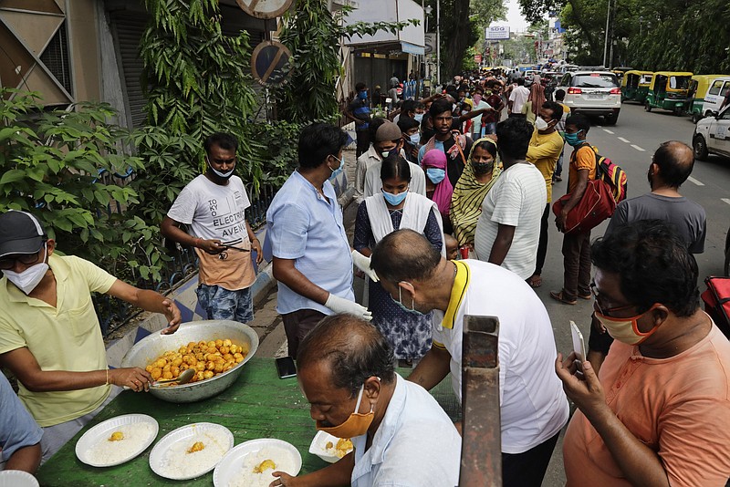 People line up Wednesday to receive free food distributed by a voluntary organization during lockdown to curb the spread of the coronavirus pandemic in Kolkata, India.
(AP/Bikas Das)