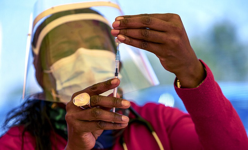 FILE - In this May 25, 2021, file photo, a health worker prepares a dose of the Pfizer coronavirus vaccine at the Orange Farm Clinic near Johannesburg. (AP/Themba Hadebe, File)