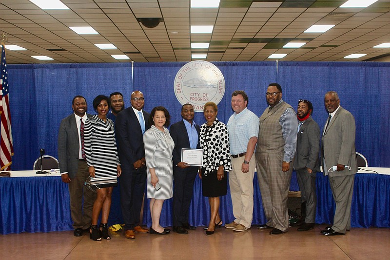 Council members Bruce Lockett (from left), Joni Alexander, Glen Brown Jr., Go Forward Pine Bluff CEO Ryan Watley, GFPB’s education coordinator Mildred Franco, Jalon Hughes, Mayor Shirley Washington, council members Steven Shaner, Lloyd Holcomb Jr., Glen Brown Sr., and Ivan Whitfield pose for a photograph as the city officials congratulate Hughes on his accomplishment. 
(Pine Bluff Commercial/Eplunus Colvin)