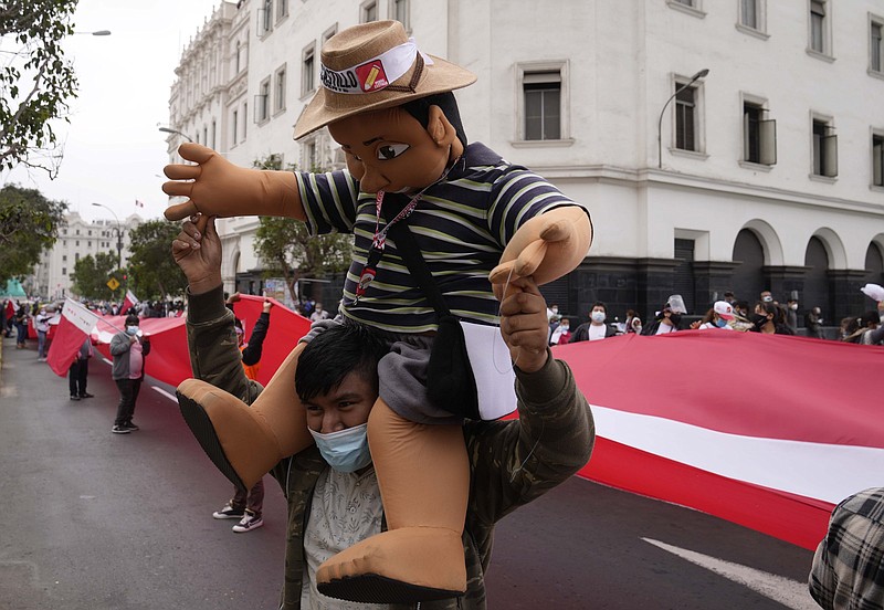 A supporter of candidate Pedro Castillo carries a puppet in Castillo’s likeness during a march Wednesday in Lima as Peruvians wait to learn the outcome of the presidential election.
(AP/Martin Mejia)