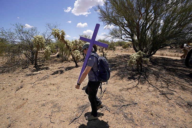 Alyssa Quintanilla, part of the Tucson Samaritans volunteer group, carries a cross to be installed at the site of the migrant who died in the desert some time ago, in the desert near Three Points, Ariz. Protecting migrants and honoring the humanity of those who died on the perilous trail is a kind of religion in southern Arizona where spiritual leaders four decades ago founded the Sanctuary Movement, a campaign to shelter Central Americans fleeing civil war, and scores of volunteers carry on their legacy today.
(AP/Ross D. Franklin)