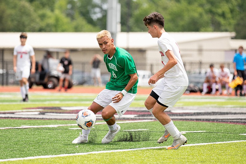 Van Buren’s Pedro Rodriguez (left) looks to pass the ball to a teammate Saturday during the Class 5A boys soccer championship in Benton. (Arkansas Democrat-Gazette/Justin Cunningham)